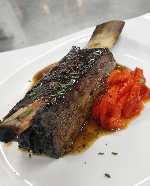 Costilla de res gourmet con corteza chamuscada, pimientos rojos asados, en El Paraje del Chef en Granada