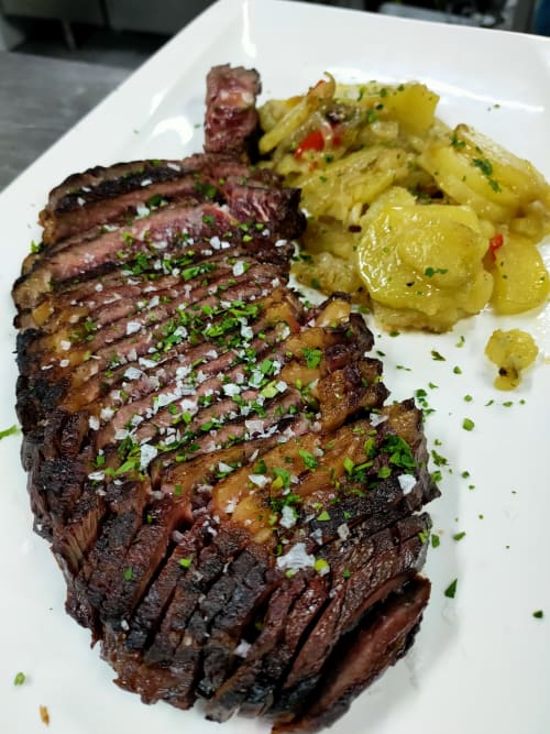 Carne asada en filetes con guarnición de hierbas y papas al horno en El Paraje del Chef, Granada