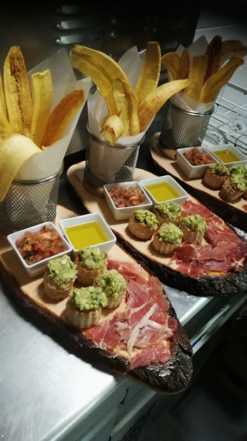 Tapas gourmet con jamón ibérico, tostadas de guacamole y chips de plátano frito en El Paraje del Chef, Granada