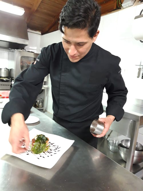 Chef emplazando un plato gourmet en el espacio gastronómico El Paraje del Chef en Granada, España