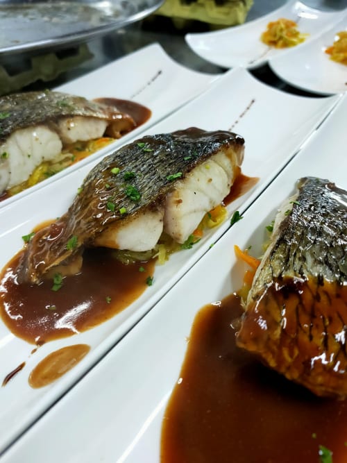 Filetes de pescado a la sartén con piel crujiente, verduras y salsa marrón en El Paraje del Chef, Granada