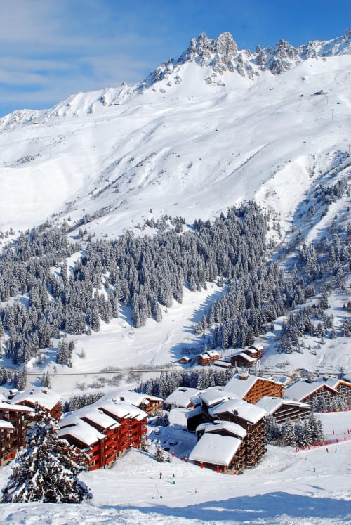 Station alpine CMD Méribel Le Pralin nichée dans les pentes enneigées, chalets et forêts aux Allues