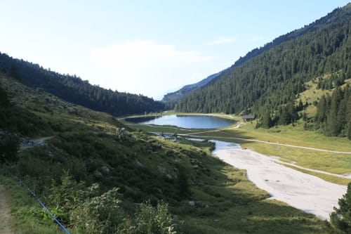 Lac alpin entouré de forêts de conifères et de prairies près du CMD Méribel Le Pralin aux Allues, France