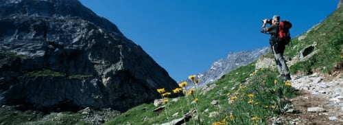 Randonneur en montagne avec sac à dos sur sentier alpin près de CMD Méribel Le Pralin, Les Allues, entouré de pentes verdoyantes