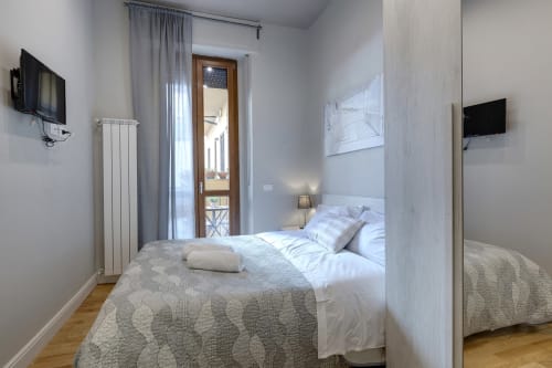Camera moderna al Sleep tight Florence B&B con vista giardino, TV a schermo piatto, radiatore bianco e accesso al balcone a Firenze