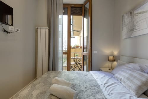 Camera da letto luminosa a Sleep tight con letto matrimoniale, balcone con vista sul giardino, TV e comfort moderni