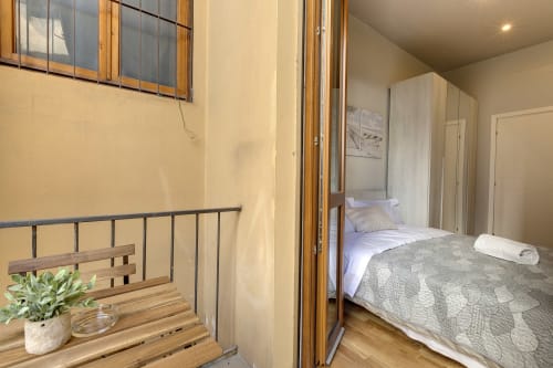 Accogliente camera da letto in B&B a Firenze con vista sul giardino, letto con biancheria grigia, armadio in legno e servizi moderni