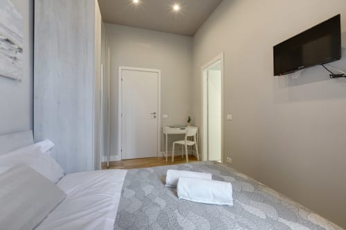 Camera moderna al Sleep tight Florence B&B a Firenze con TV a schermo piatto, scrivania e vista sul giardino