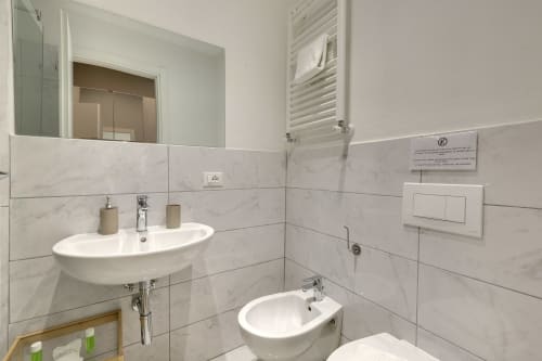 Bagno moderno a Sleep tight Florence con lavabo bianco, bidet, piastrelle in marmo e scaldasalviette