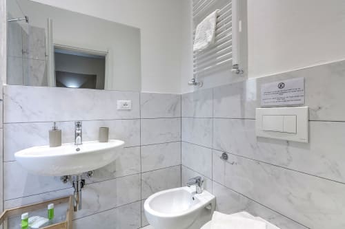 Moderno bagno in marmo a Sleep Tight Florence con doppio lavabo, doccia e accessori contemporanei