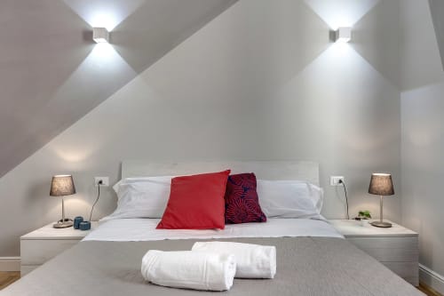 Accogliente camera standard Sleep tight Florence con letto moderno, cuscini rossi, biancheria bianca e illuminazione ambientale