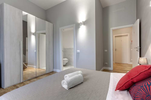 Camera moderna presso Sleep tight Florence con armadio a specchio, letto con asciugamani arrotolati e bagno ensuite a Firenze
