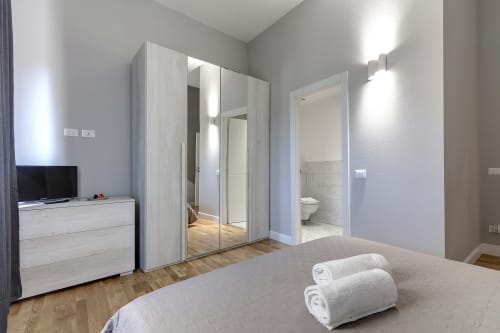 Camera moderna presso Sleep tight Florence BnB a Firenze con armadio a specchio, TV e bagno en-suite
