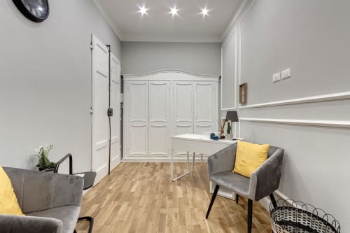 Camera moderna del Sleep tight Florence BnB a Firenze con sedie grigie, armadio bianco e pavimento in legno
