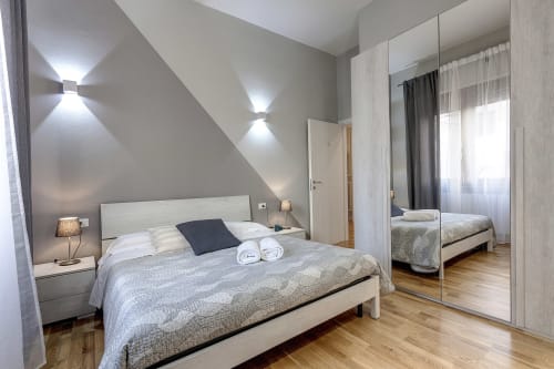 Camera moderna al Sleep tight Florence BnB a Firenze con letto matrimoniale, armadio specchiato e illuminazione contemporanea
