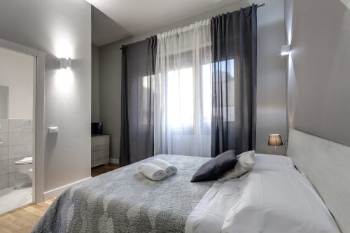 Camera moderna a Sleep tight Florence con accenti grigio, letto matrimoniale, tende scure e bagno privato