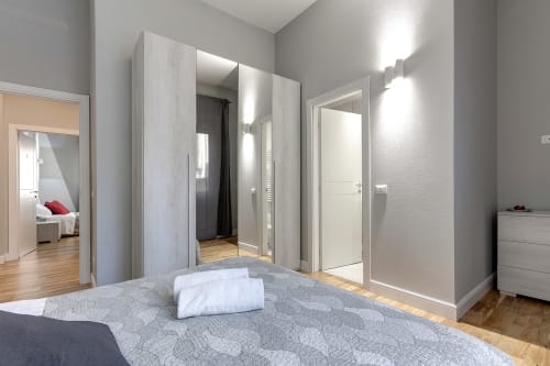 Camera moderna presso Sleep tight Florence con cabina doccia, letto e arredamenti bianchi a Firenze