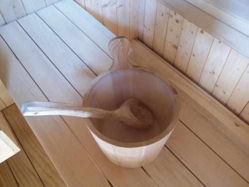Secchio in legno con mestolo nella sauna della B&B Emozioni Relax di Mantova
