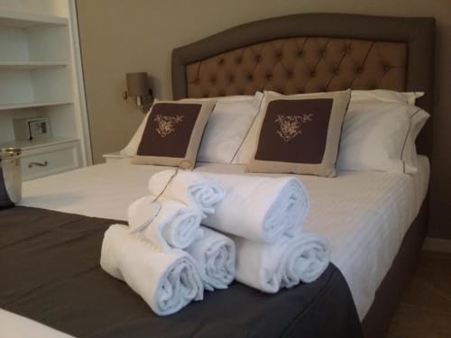 Camera elegantemente arredata presso B&B Emozioni Relax a Mantova con testata trapuntata, biancheria bianca e cuscini decorativi