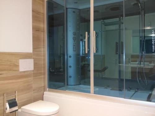 Bagno moderno presso B&B Emozioni Relax a Mantova con cabina doccia in vetro e pareti rivestite in legno
