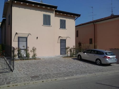 B&B Emozioni Relax a Borgo Virgilio, Mantova - casa color crema con persiane blu e auto bianca parcheggiata