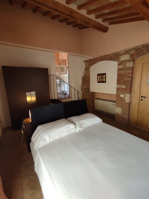 Camera moderna a La Locanda del Vino Nobile a Montepulciano con travi a vista, archi in laterizio e vedute sulla città