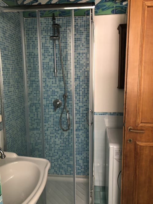 Modern shower enclosure with blue mosaic tiles at Orso Luxury Apartments, Roma