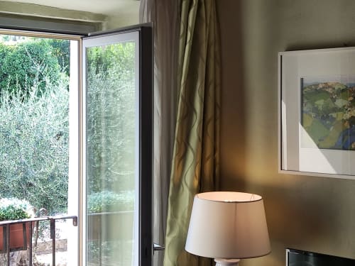 Stanza luminosa alla Locanda del Vino Nobile di Montepulciano con vista giardino attraverso porte finestre e eleganti arredi