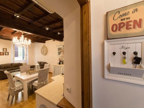 Orso Luxury Apartments Roma kitchen-dining area with open sign, keys holder, and chandelier