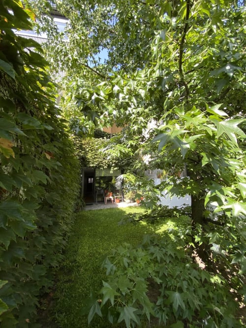 Lush garden courtyard at Casa45 guesthouse in Porto with green foliage and patio seating