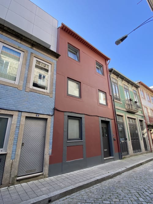 Casa45 BnB exterior on Porto street with colorful historic buildings featuring brick and painted facades