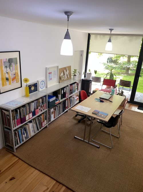 Modern home office at Casa45 Porto B&B with desk, bookshelves, pendant lighting, and garden view