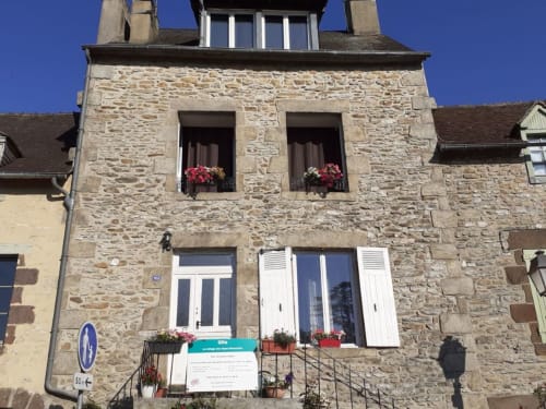 Le refuge des Alpes mancelles, façade en pierre avec jardinières de fleurs, Fresnay-sur-Sarthe