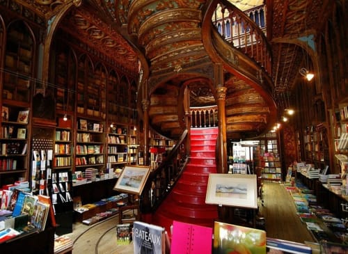 Biblioteca de madera ornamental con escalera de caracol, escalones rojos y librerías del hotel boutique Casa45 Porto