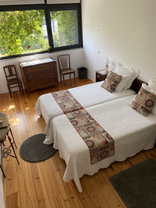 Chambre Twin avec vue sur le jardin à Casa45 Porto, deux lits avec jets de lit décorés et vue jardin par grandes fenêtres