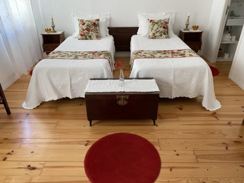 Chambre twin à Casa45 Porto avec lits blancs, oreillers à fleurs, tables de nuit en bois foncé et parquet