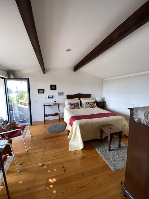 Amplio dormitorio doble en Casa45 Porto con acceso a terraza, vigas de madera y vistas a la ciudad