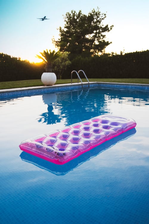 Balsa inflable rosa flotando en la piscina de Torre Gelbert, Puigcerdà con vistas al atardecer