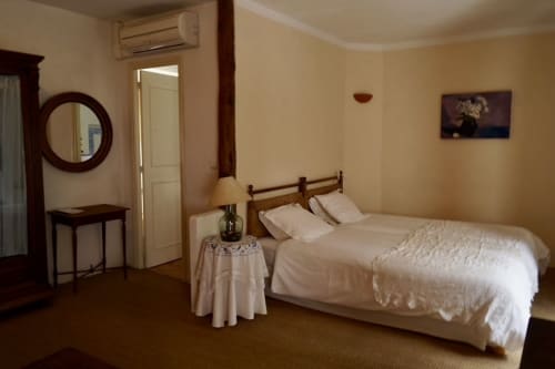 Habitación Llevant del Petit Hotel Sa Plana con cama doble, muebles de madera, aire acondicionado y vistas al jardín