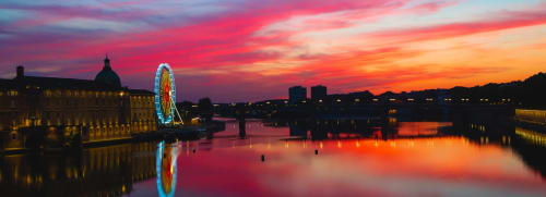Coucher de soleil sur le canal de Toulouse avec la grande roue illuminée reflétée dans l'eau, L'Insolite Spa Privatif à proximité
