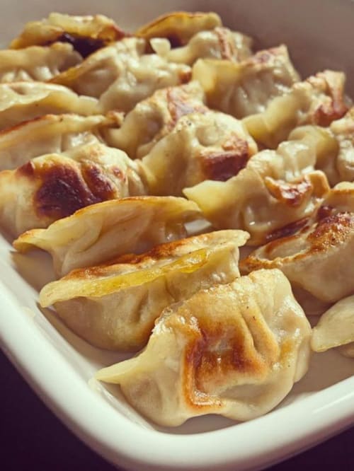 Pan-fried dumplings with golden-brown edges served at La Guirtelle, a bed and breakfast in Lainsecq, France