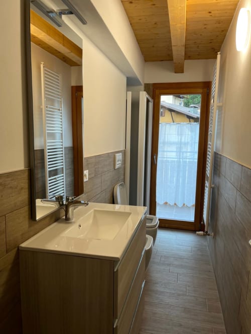Bagno moderno con vista montagna presso Residence La Corte, Vezza d'Oglio: travi in legno, lavabo elegante e vetro