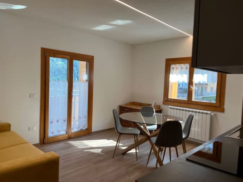Elegante zona living a Residence La Corte a Vezza d'Oglio con vista montagna, tavolo da pranzo e porte in legno