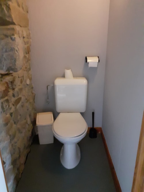 Toilettes blanches avec siège dans la salle de bain compacte de la maison d'hôtes La Ferme De Werpin, Hotton Belgique