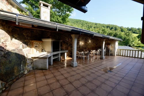 Terraza de piedra rústica con comedor con vistas a montañas boscosas en hotel Balbino, Suárbol, León