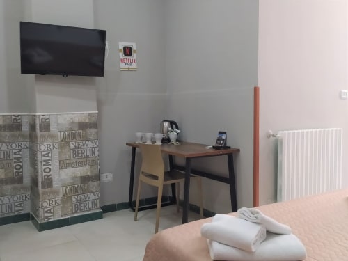 Modern family room at Royal Rooms Station Napoli with flat-screen TV, work desk, and city views in Naples, Italy