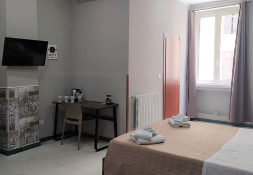 Modern family room at Royal Rooms Station Napoli with flat-screen TV, work desk, and city views in Naples, Italy