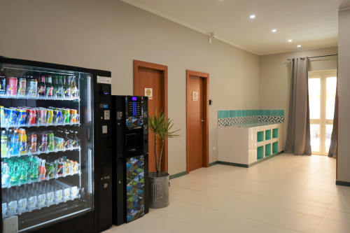 Hotel common area with vending machines, wooden doors, and green storage cabinets at Royal Rooms Station Napoli