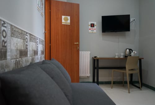Superior King Room at Royal Rooms Station Napoli with flat-screen TV, desk, grey sofa, and modern amenities in Naples, Italy