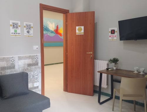 Superior King Room at Royal Rooms Station Napoli with wood door, artwork, TV, desk, chair, and city view in Naples, Italy